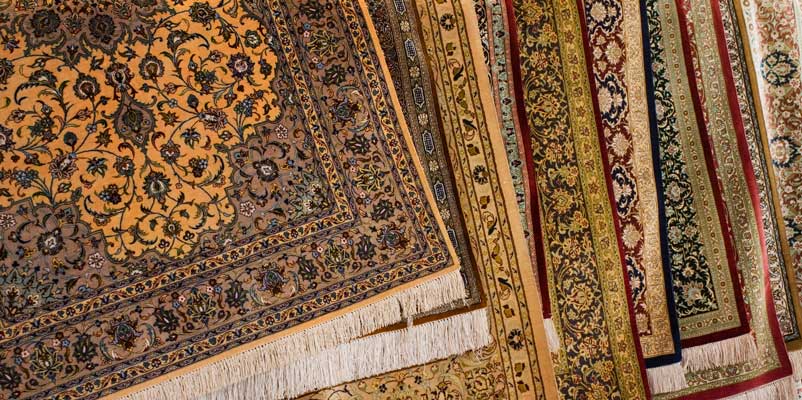 A stack of hand-knotted rugs in different colours