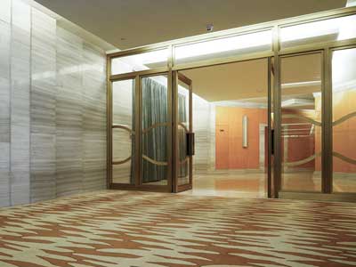 A patterned walk-off mat just inside a building's glass doors