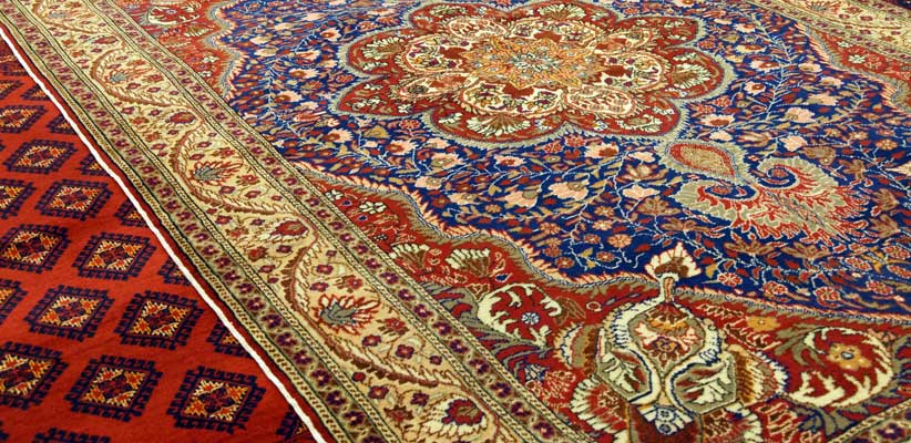 A clean Persian rug with a blue centre and a red and cream border