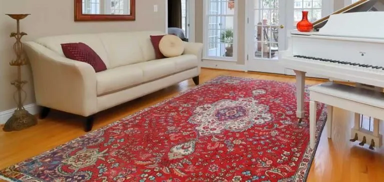 A red Persian rug in a bright living room with a white sofa