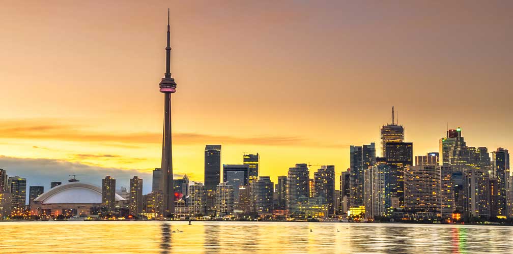 The Toronto skyline and the CN Tower at sunset, seen across the water
