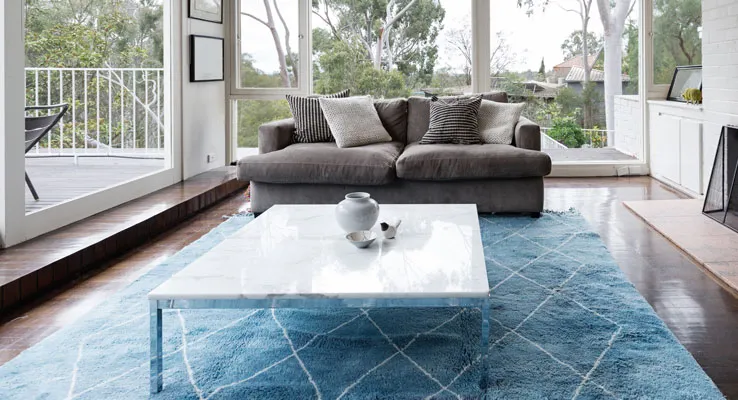 A blue wool rug in a bright living room