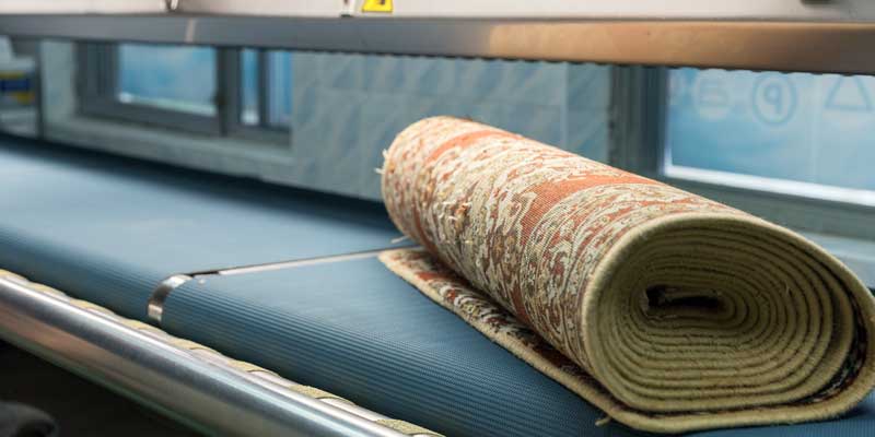 A rolled-up area rug on a work table